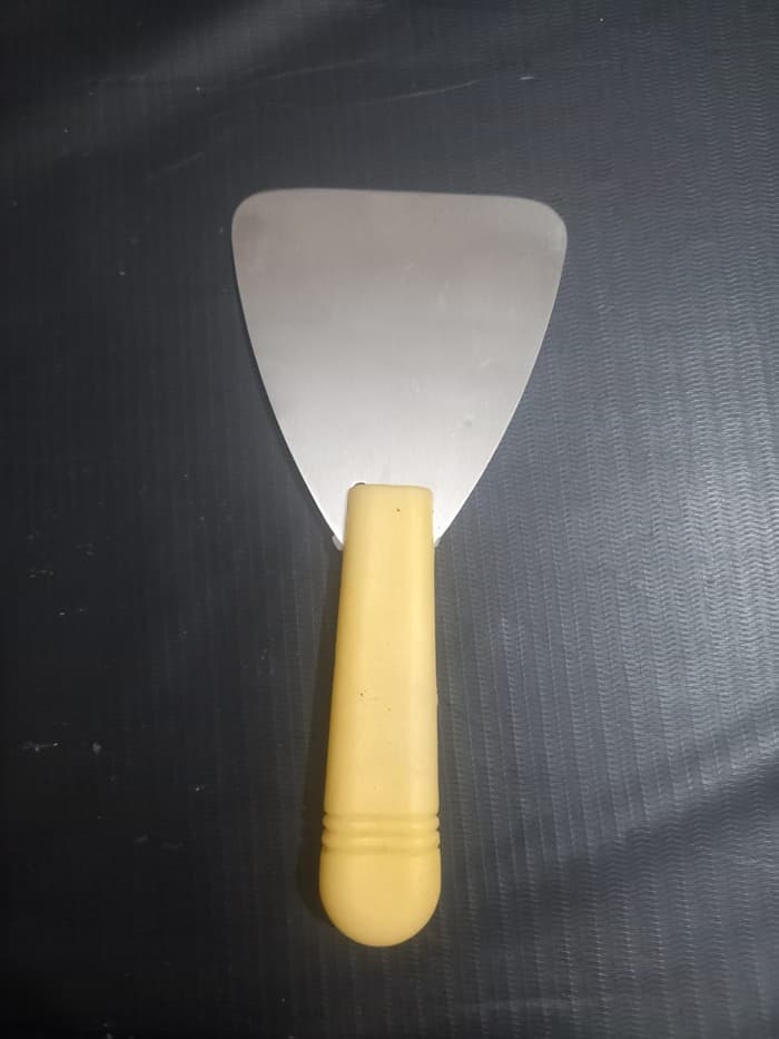 Dental Wax Paddle Lab Instrument with wide stainless steel triangular blade and yellow plastic handle – top view – compact dental lab wax spatula for denture wax-up and general dental laboratory wax work worldwide
